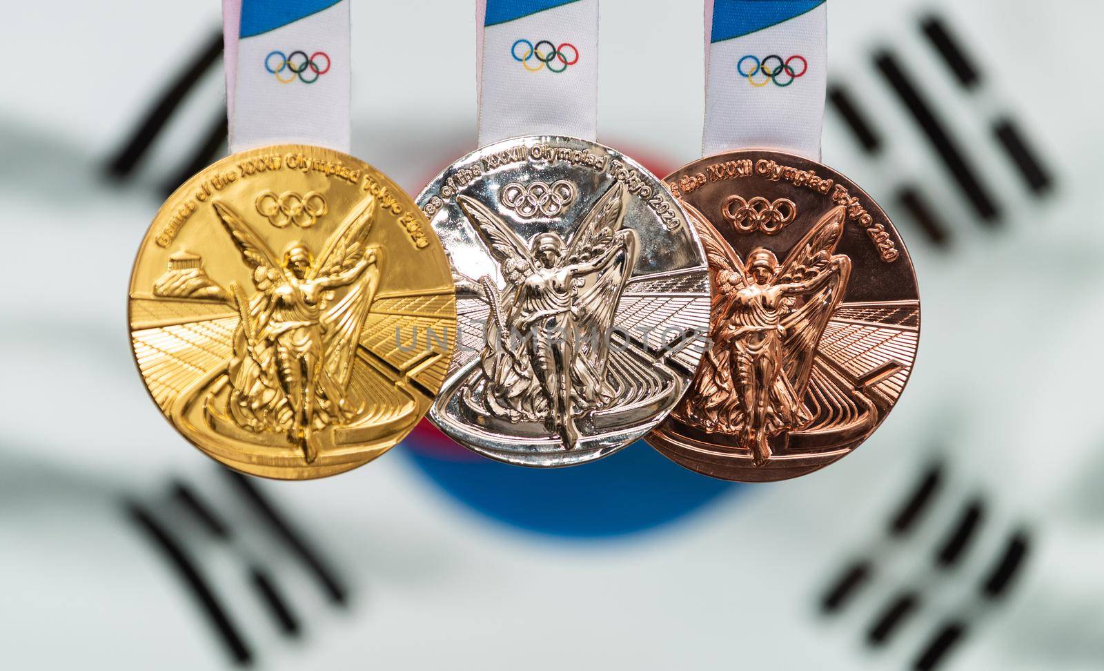 April 25, 2021 Tokyo, Japan. Gold, silver and bronze medals of the XXXII Summer Olympic Games 2020 in Tokyo on the background of the flag of South Korea.