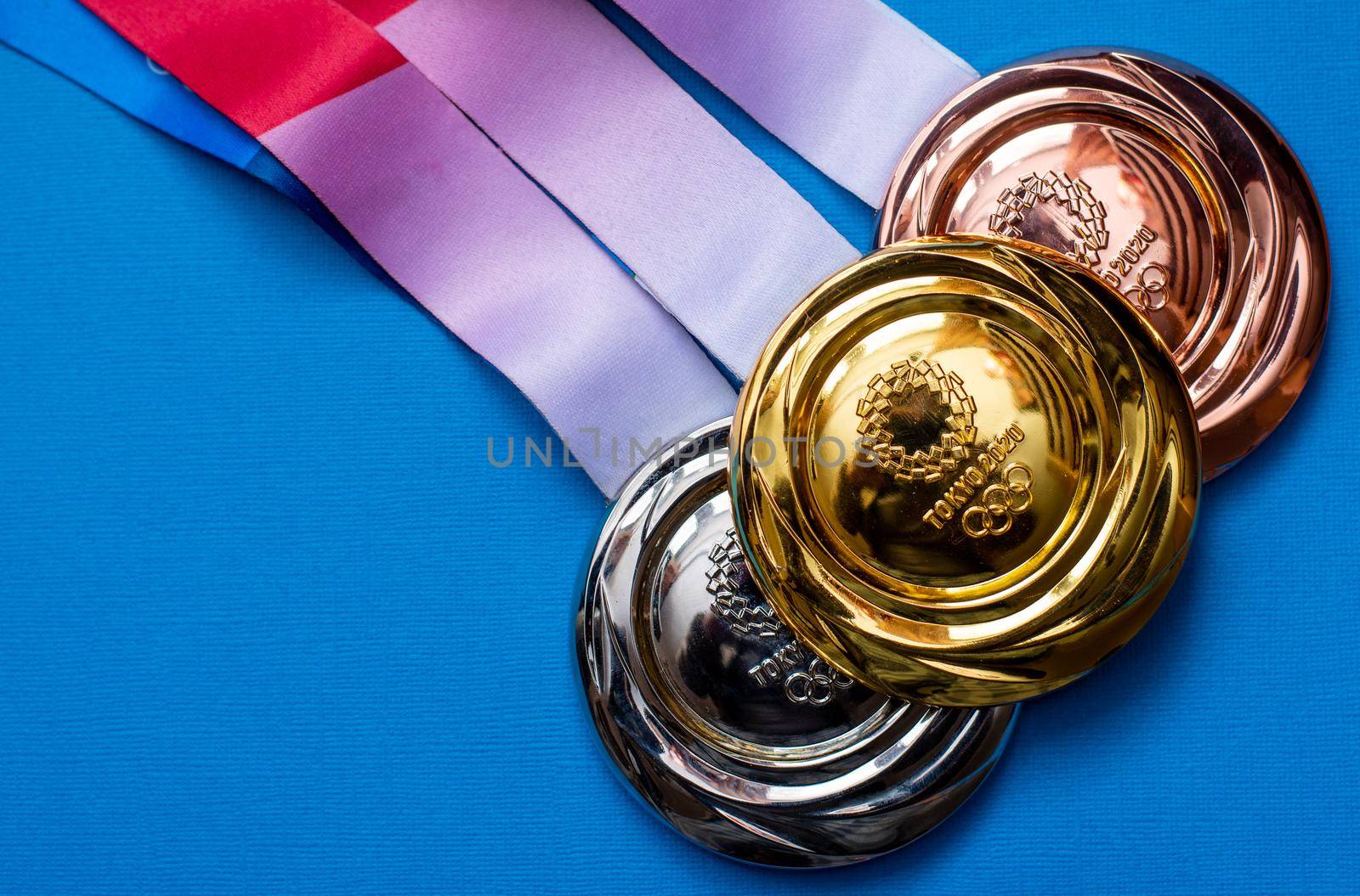 April 25, 2021 Tokyo, Japan. Gold, silver and bronze medals of the XXXII Summer Olympic Games in Tokyo on a blue background.