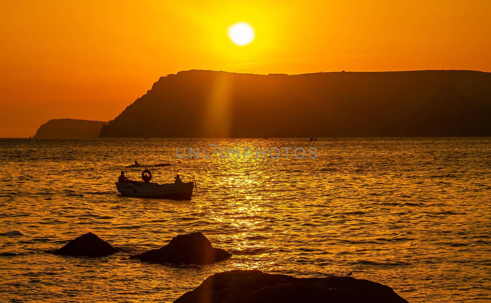A pleasure boat in a quiet bay of the Black Sea in the light of the setting sun.