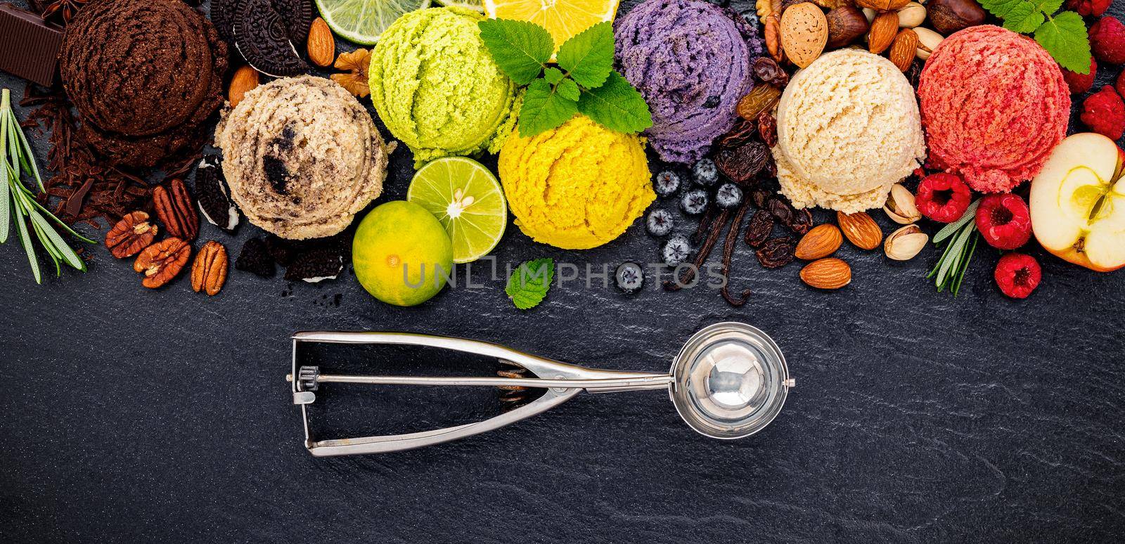 Various of ice cream flavor ball blueberry ,lime ,pistachio ,almond ,orange ,chocolate and vanilla set up on dark stone background . Summer and Sweet menu concept. by kerdkanno