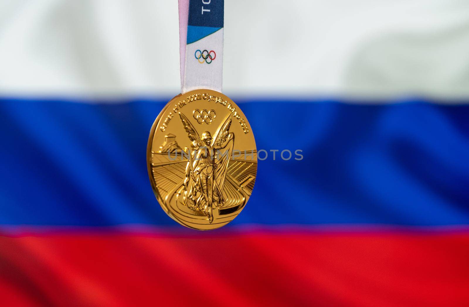 April 25, 2021 Tokyo, Japan. Gold medal of the XXXII Summer Olympic Games 2020 in Tokyo on the background of the flag of Russia.