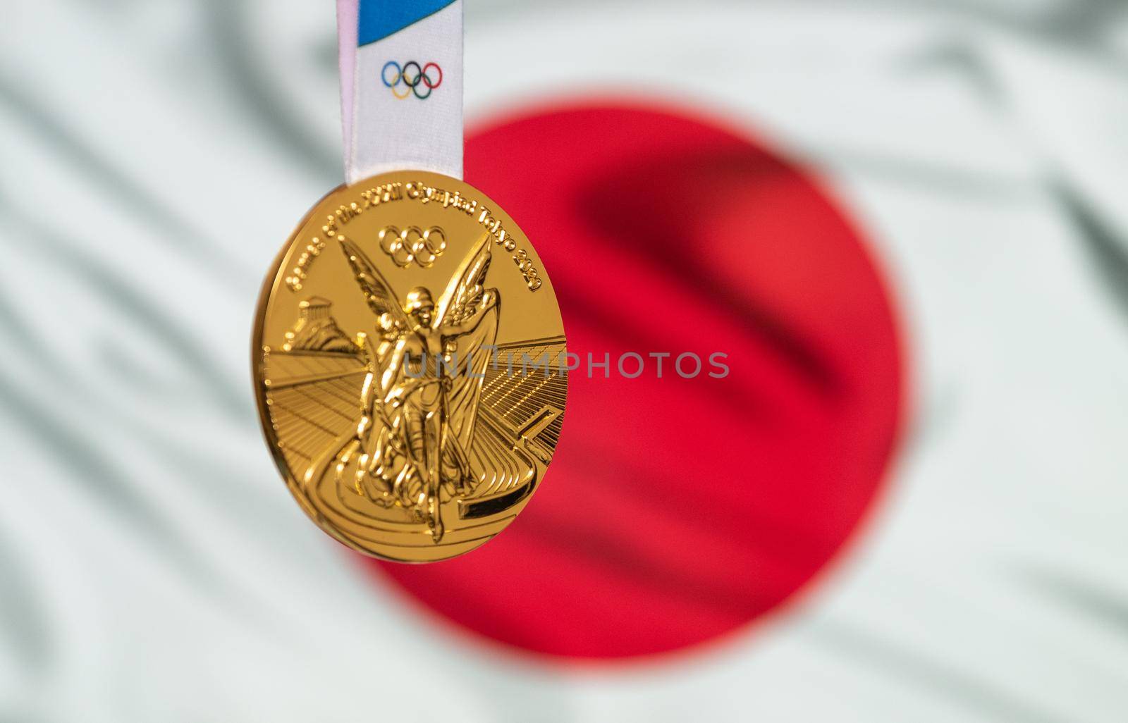April 25, 2021 Tokyo, Japan. Gold medal of the XXXII Summer Olympic Games 2020 in Tokyo on the background of the flag of Japan.