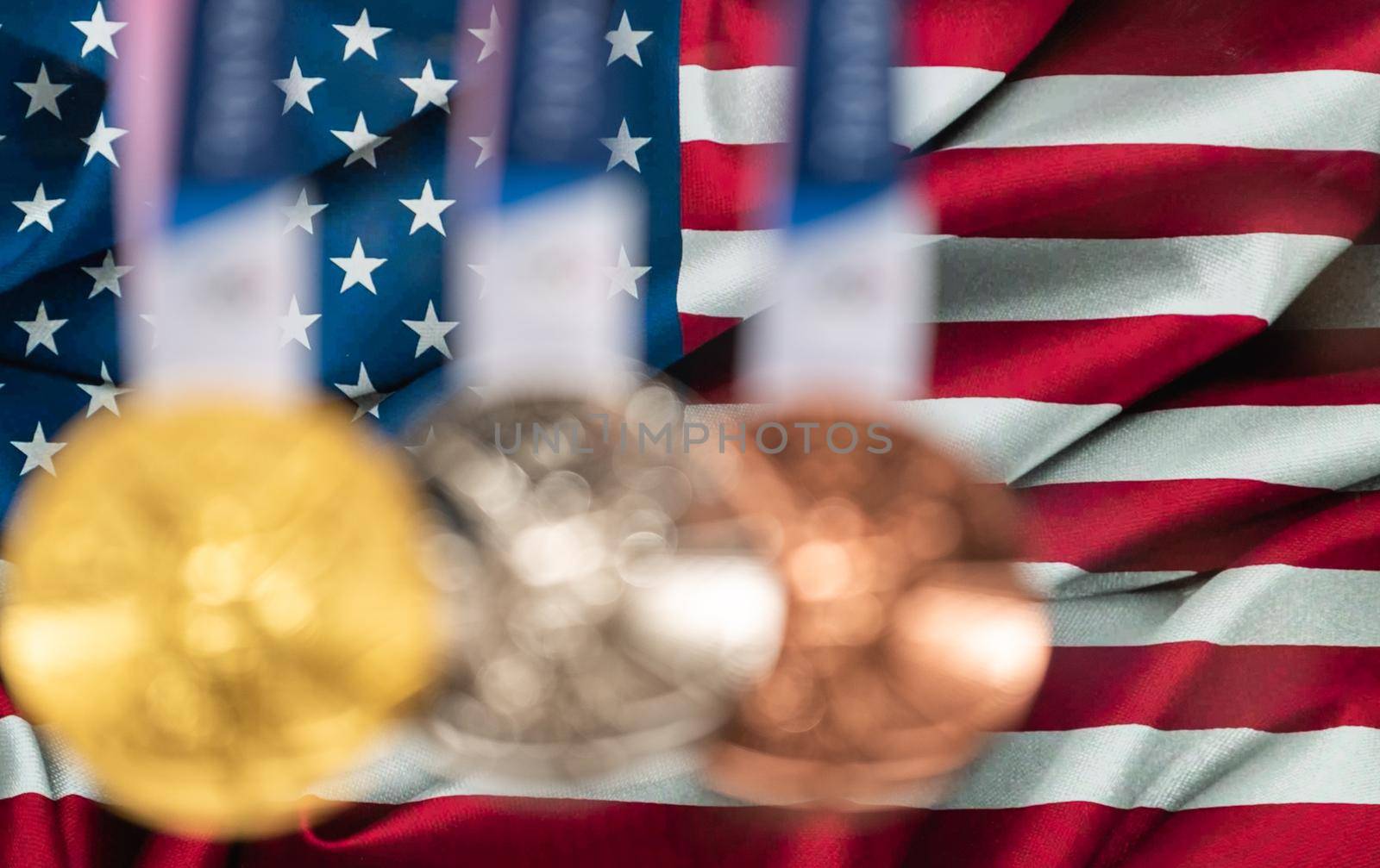 April 25, 2021 Tokyo, Japan. Gold, silver and bronze medals of the XXXII Summer Olympic Games 2020 in Tokyo on the background of the US flag.