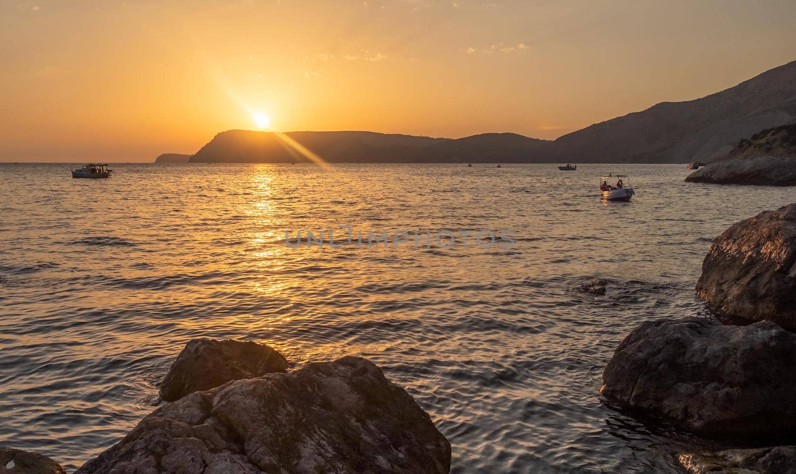 A pleasure boat in a quiet bay of the Black Sea in the light of the setting sun.