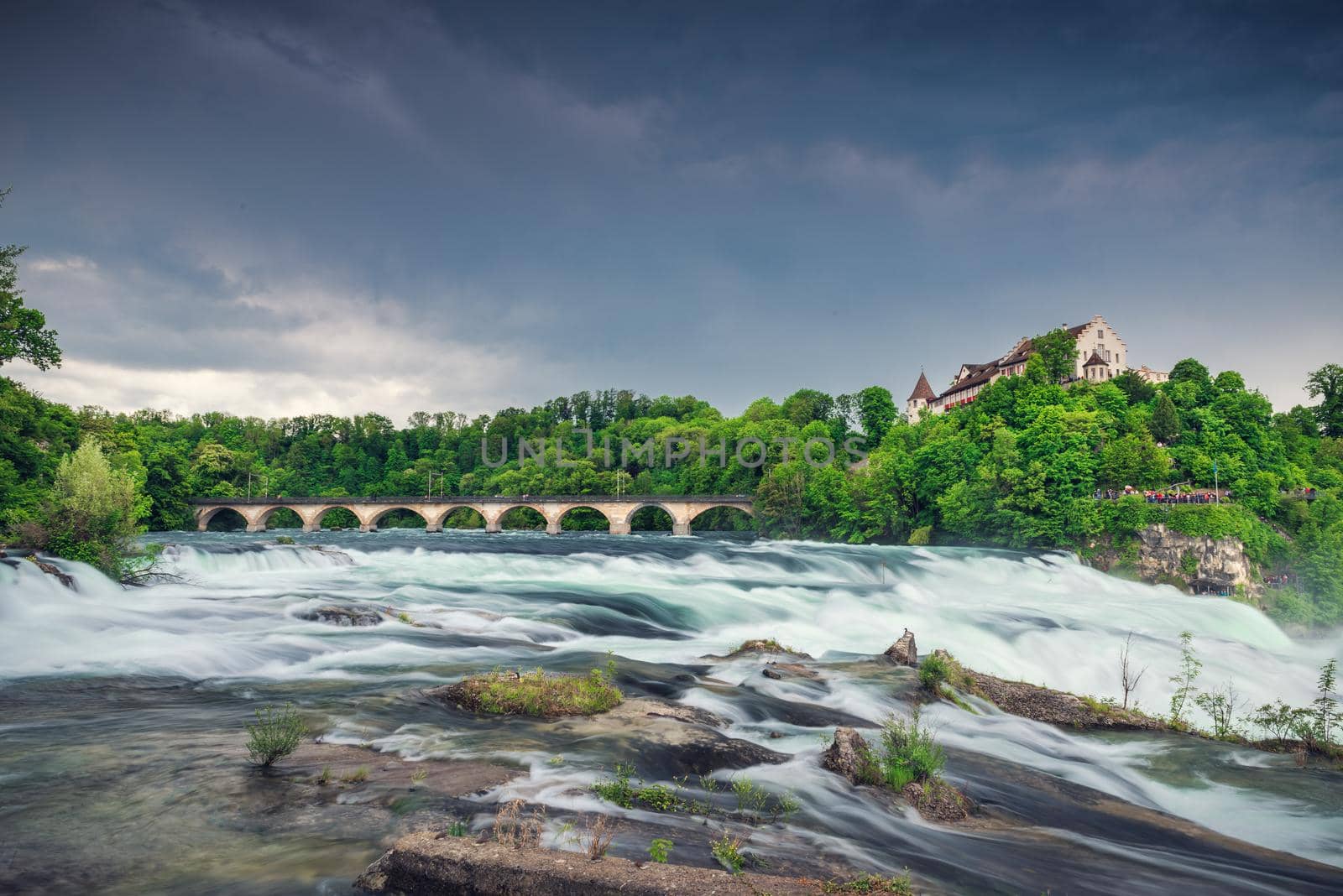 Natural Scenery of Rhine Falls and Swiss Church Culture at Schaffhausen City, Switzerland. Beautiful Nature Waterfront View of Rhine River With Architecture Historical Church Building in Summer.  by MahaHeang245789