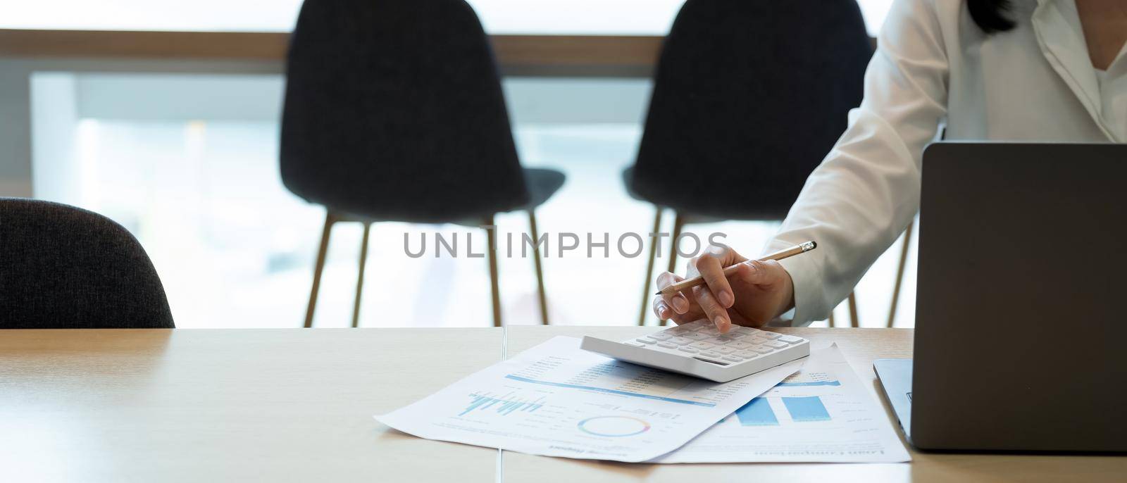 Close up businesswoman using calculator working at office with reports document financial. accounting finance concept by nateemee