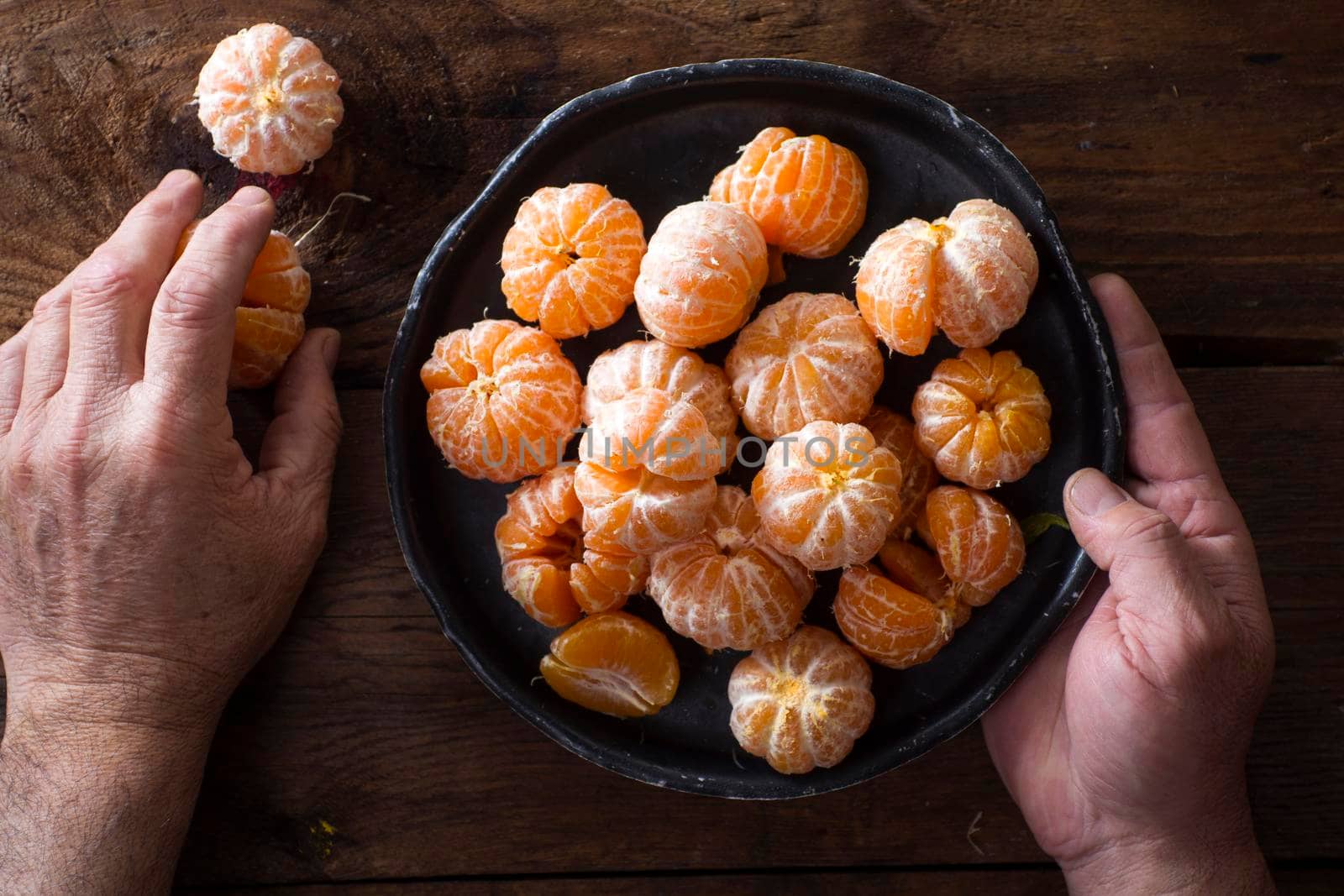 Presentation of Small peeled mandarin oranges on old wooden table