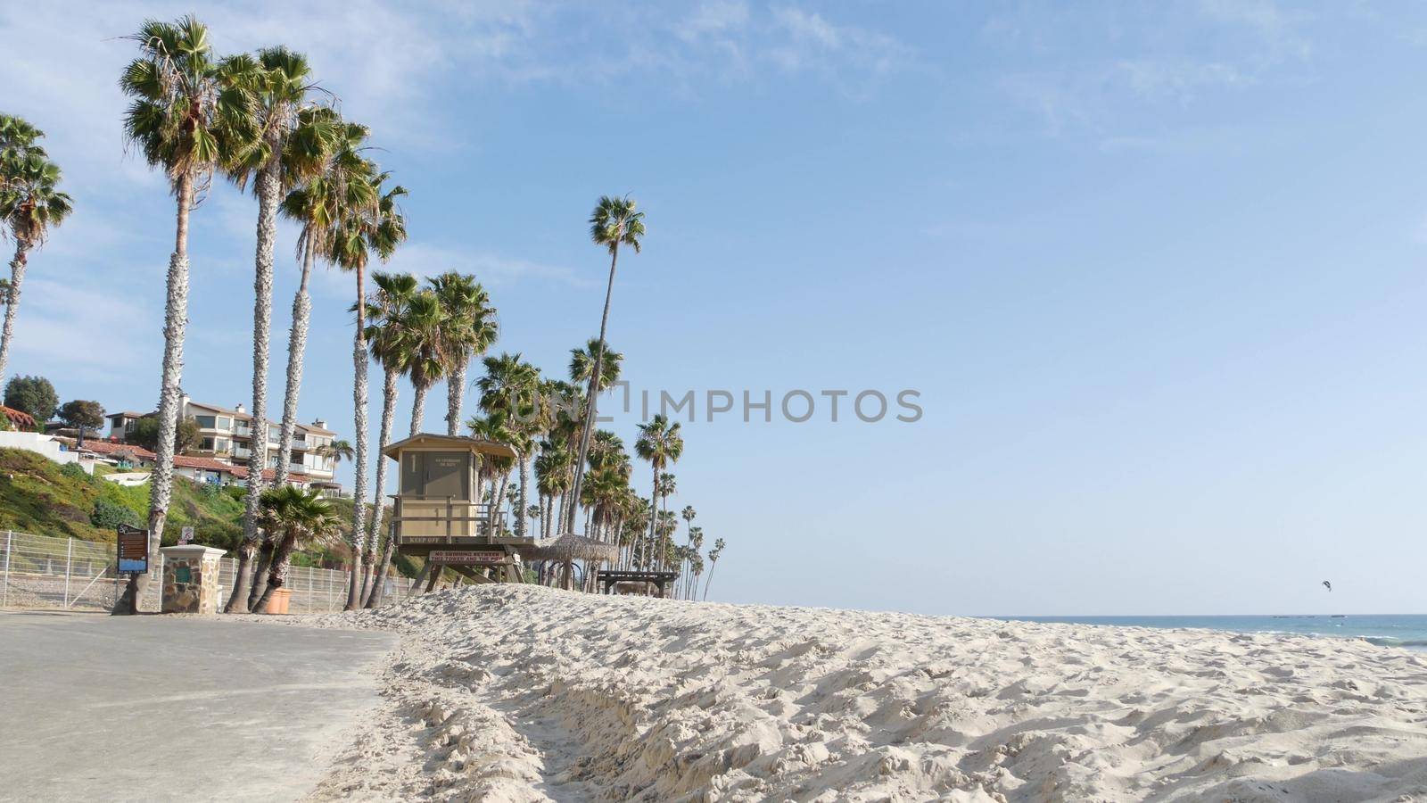 Palm trees on white sandy beach, ocean sea coast in California USA. Lifeguard tower, watchtower hut. by DogoraSun