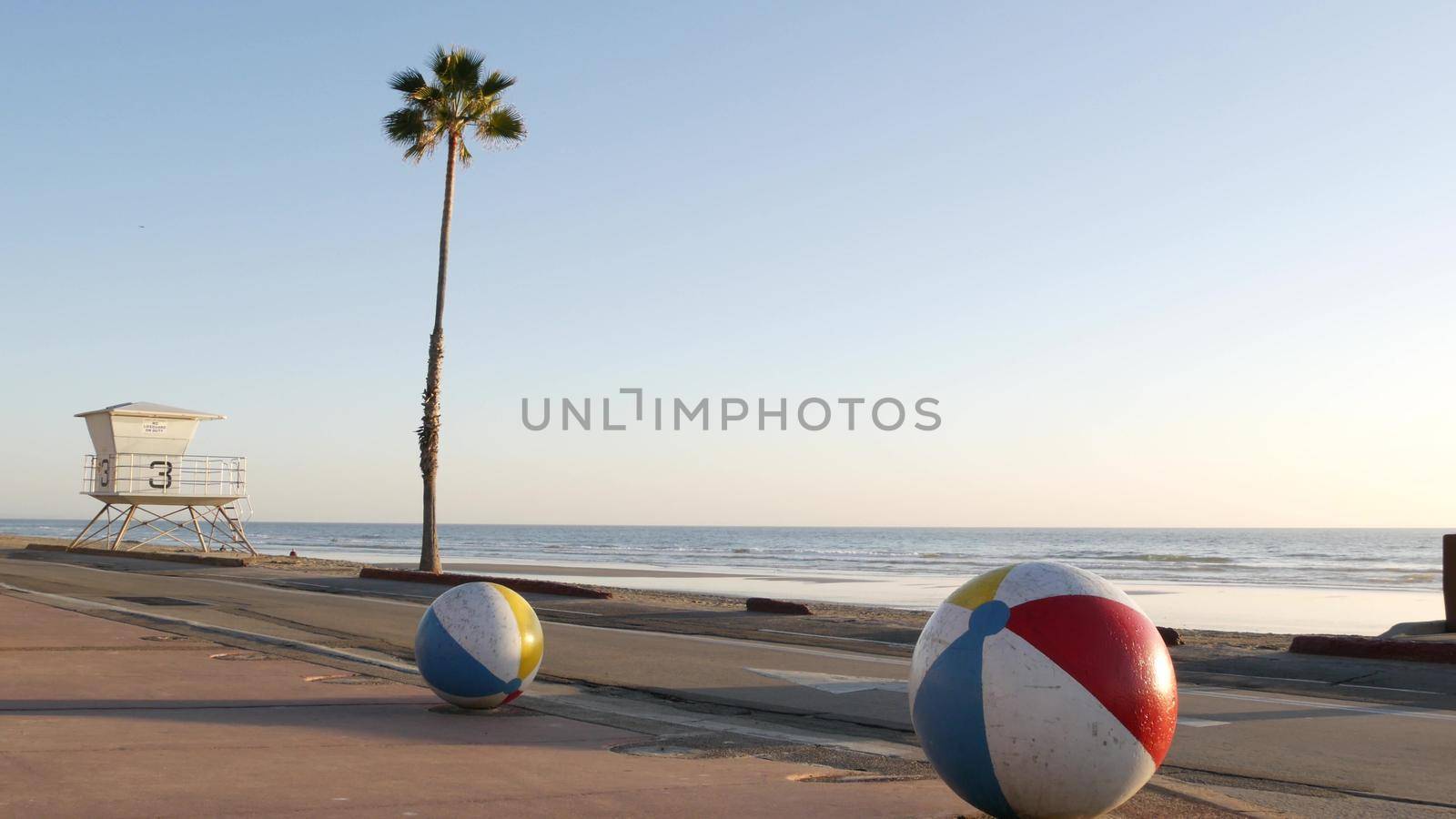 Ocean beach California USA. Ball, lifeguard tower, life guard watchtower hut, beachfront palm tree. by DogoraSun