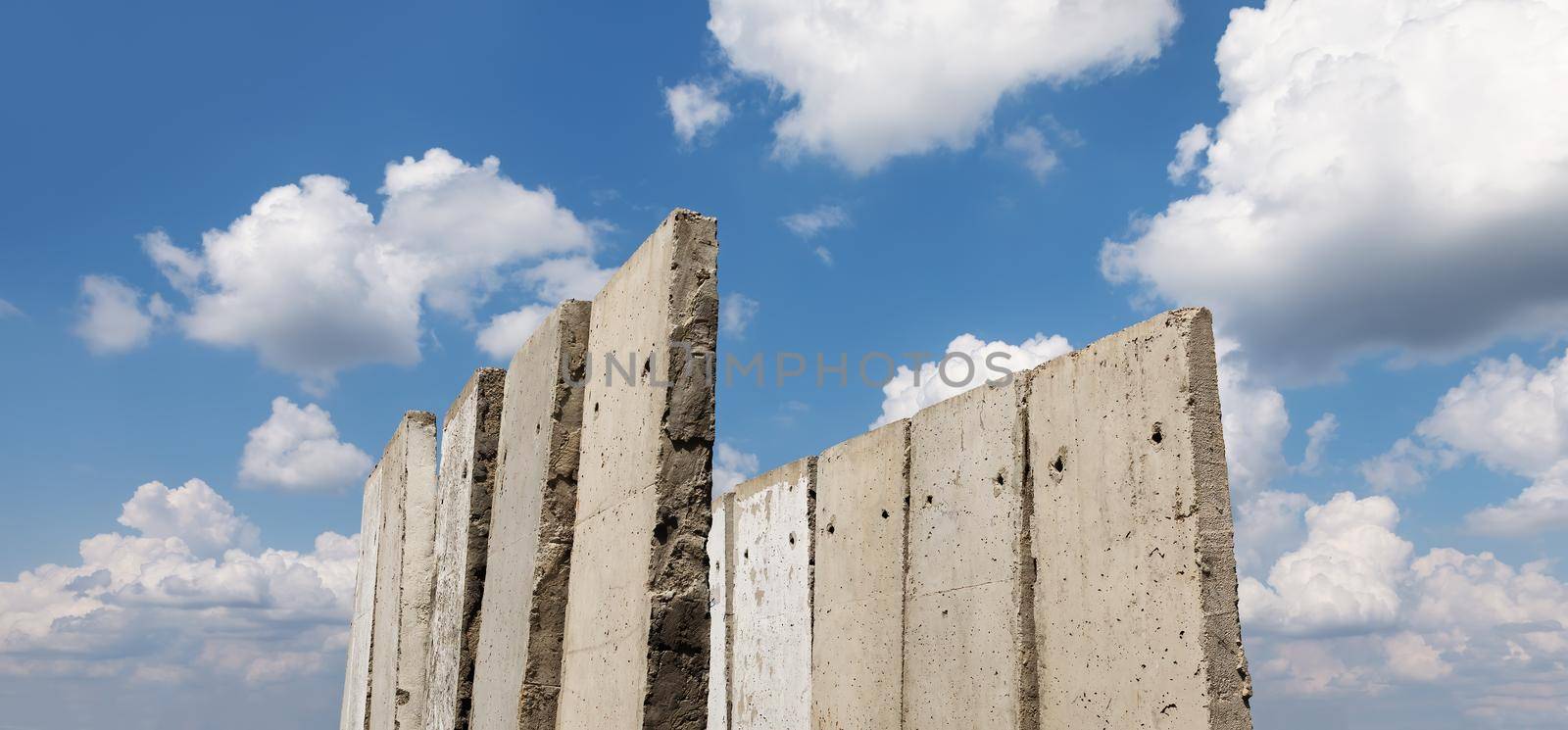 Old concrete slabs standing on a summer sunny day in the field. Old unfinished building