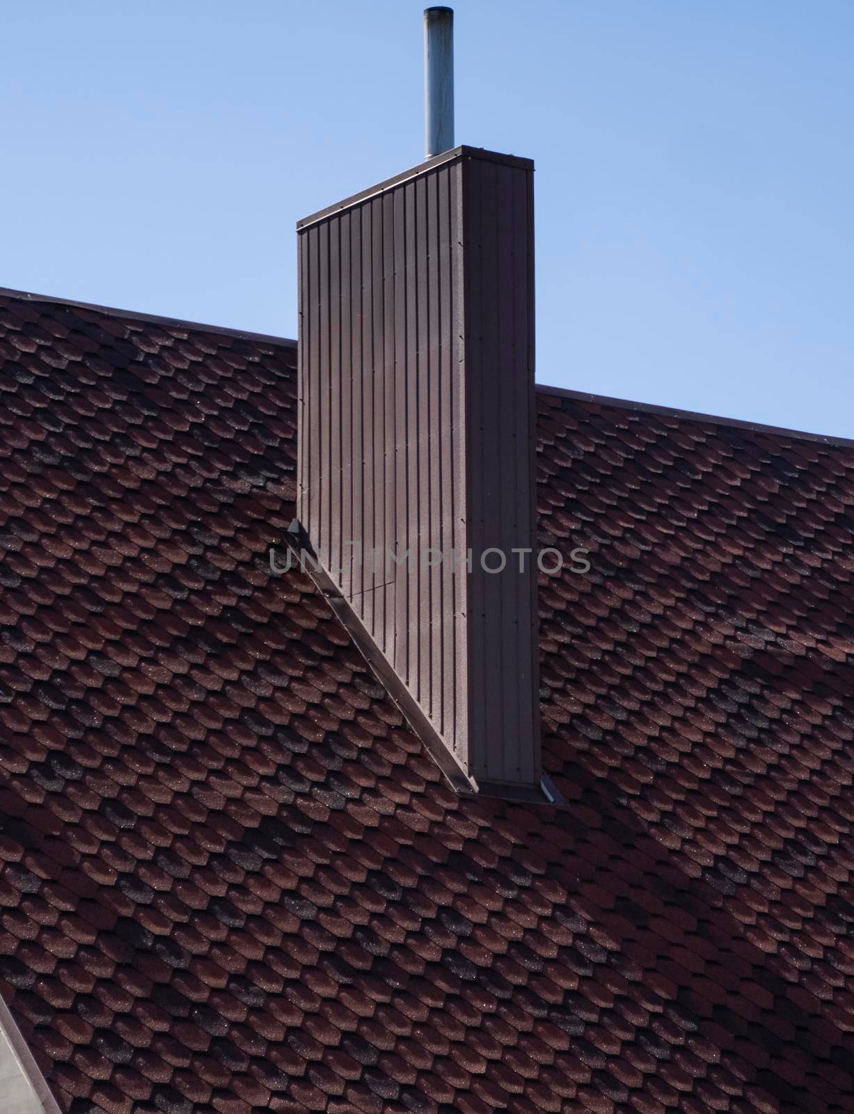 Brown corrugated metal profile roof installed on a modern house. The roof of corrugated sheet. Roofing of metal profile wavy shape. Modern roof made of metal. Metal roofing
