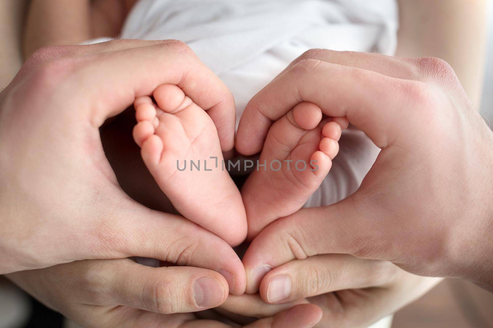 Children's feet in hold hands of mother and father. Mother, father and Child. Happy Family people concept. High quality photo