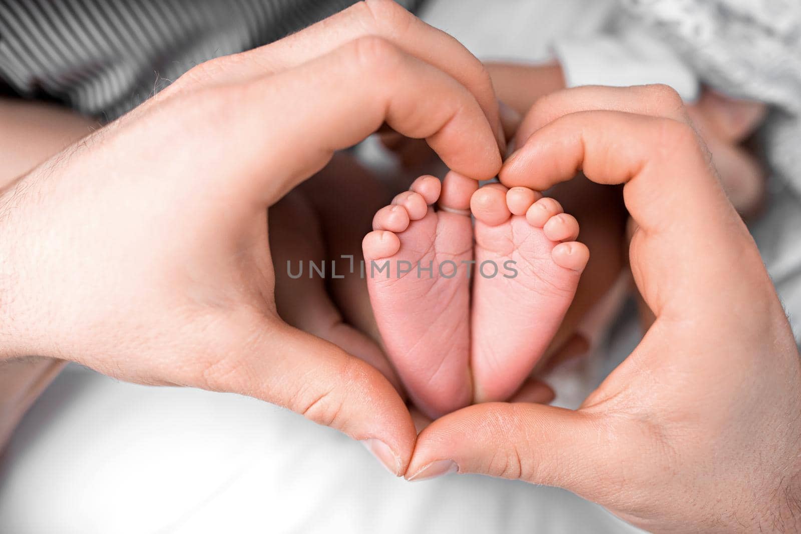 Feet of a newborn in the hands of mom in the shape of a heart. High quality photo