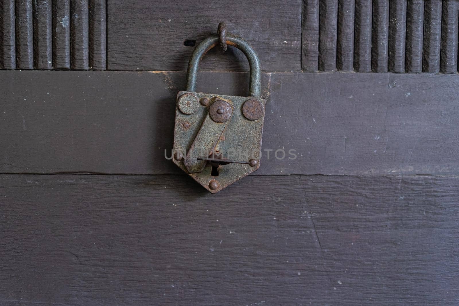 Old rusty padlock on the wooden door by domonite