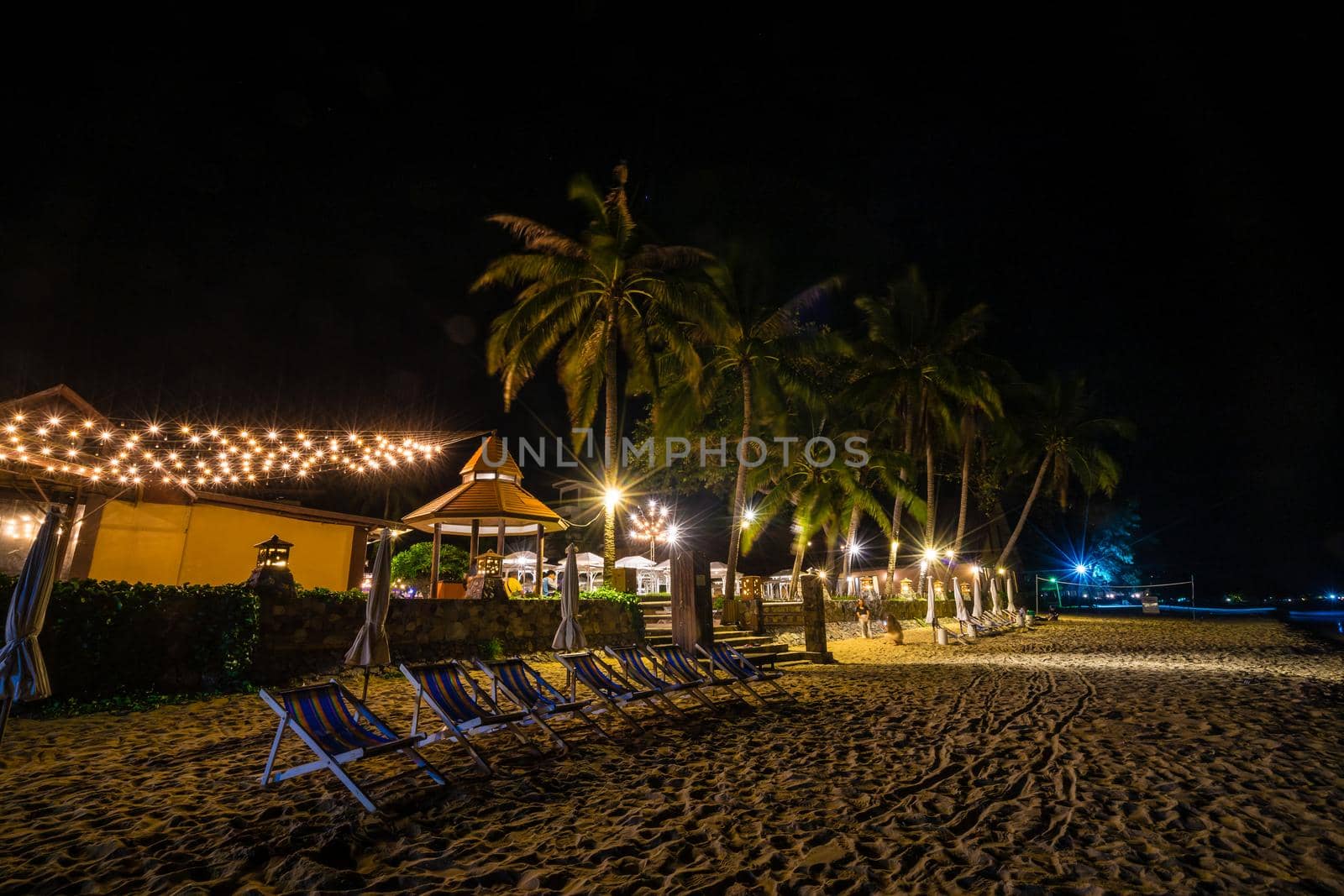 Beach chairs on the  sand beach in summer at night by domonite