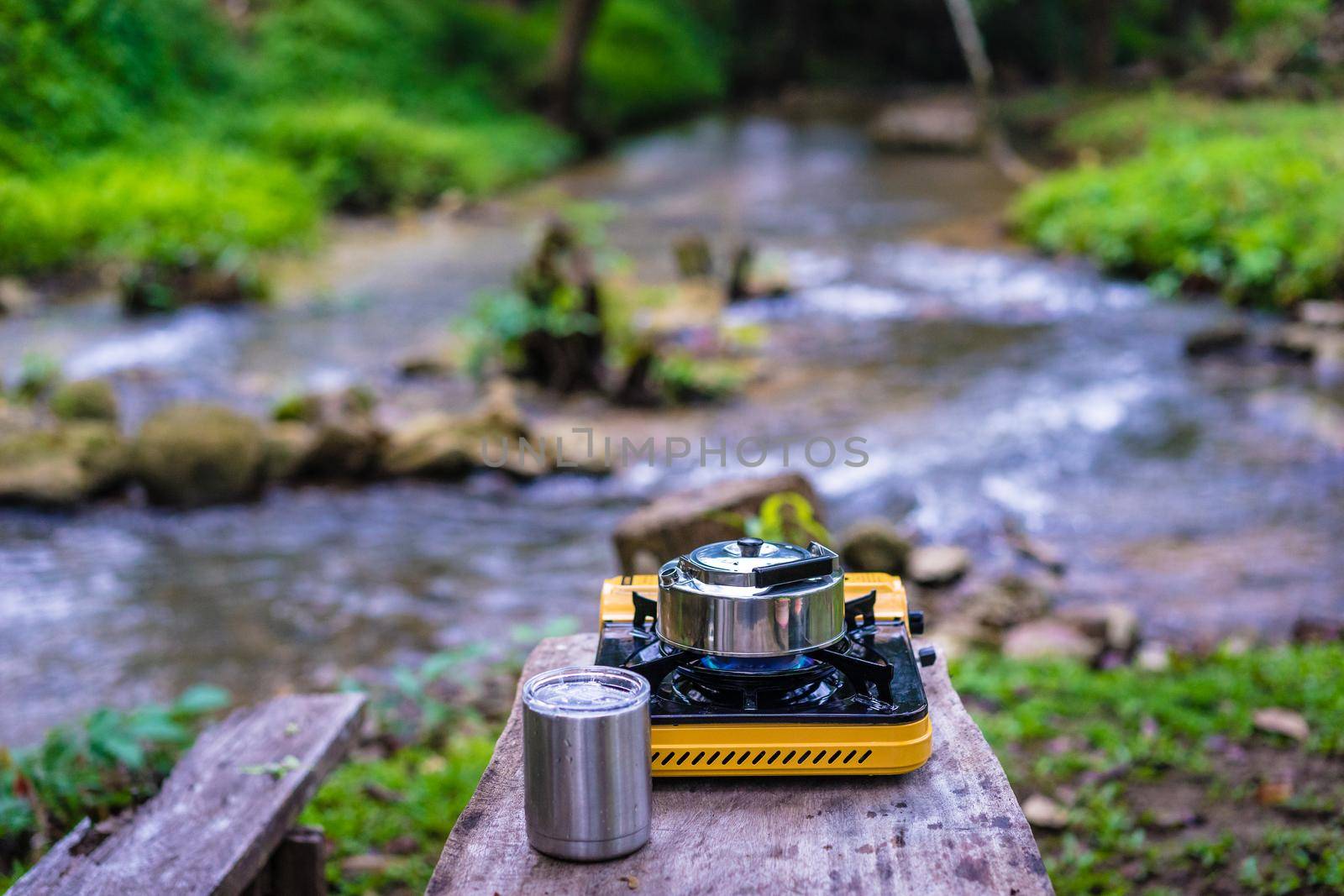 Picnic gas stove and aluminum teapot for boiling water during camping by domonite