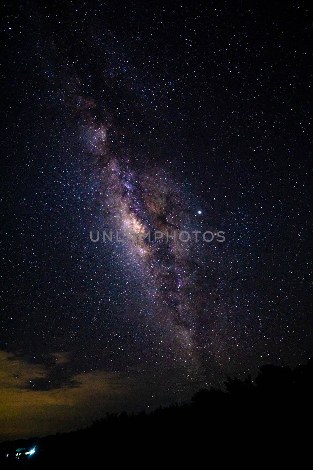 Night landscape with the Milky Way and light from home at mountains in Thailand