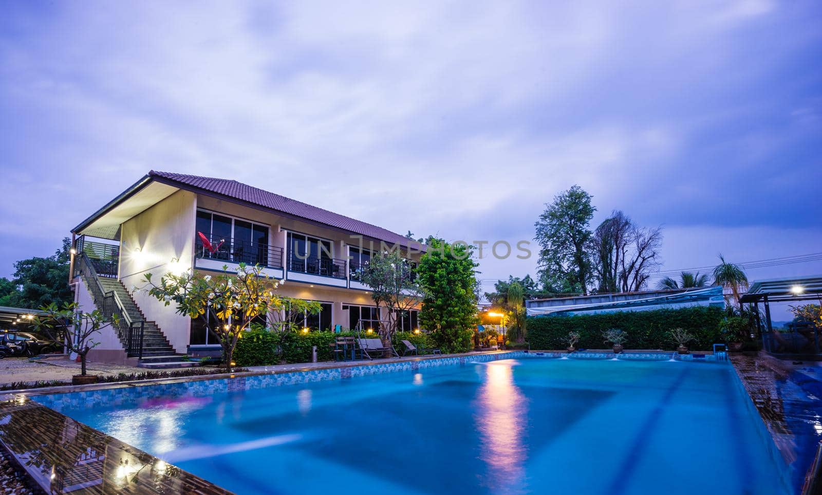 Modern building with swimming pool at evening time by domonite