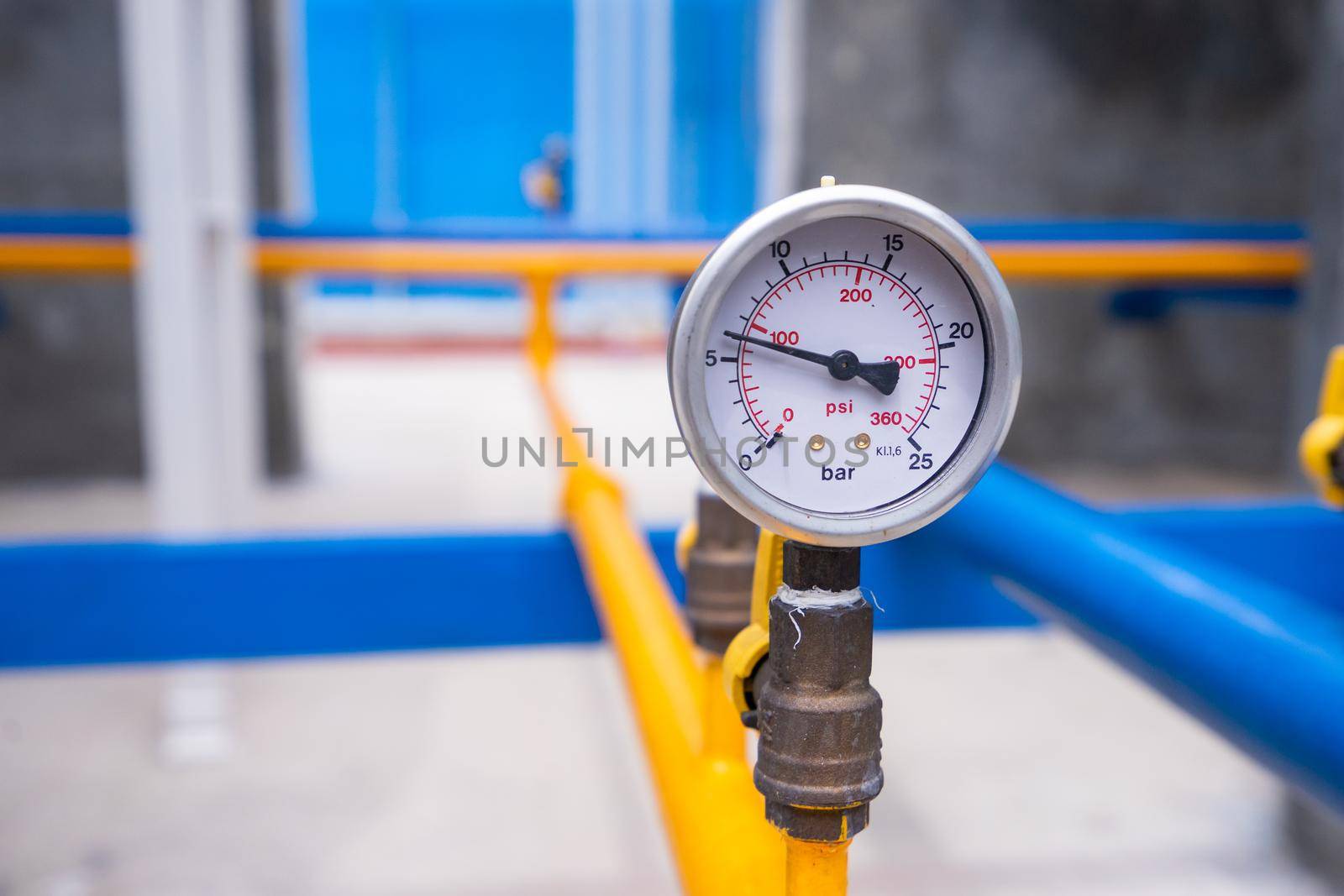 Closeup of manometer for measuring gas pressure. Pipes and valves at industrial plant. by domonite