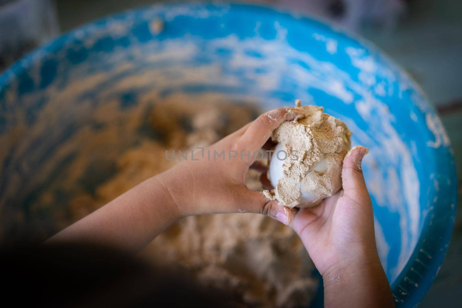 Little girl make salted egg in her hand