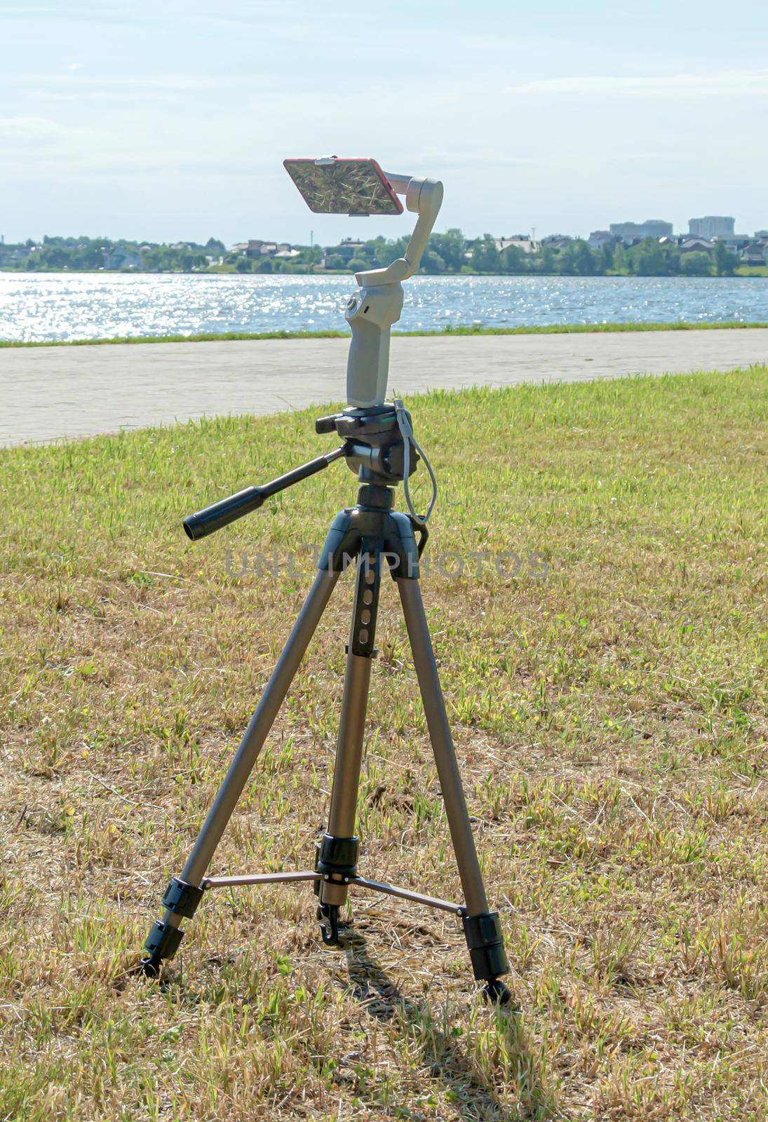 smartphone is mounted on a studicam and mounted on a tripod, a blurry background with bokeh elements by Grommik