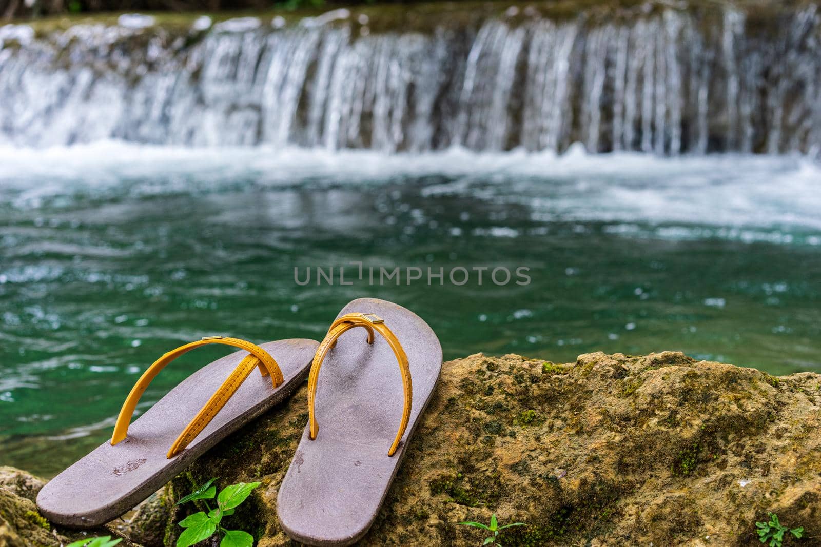 Slippers were placed on the rock in the waterfall