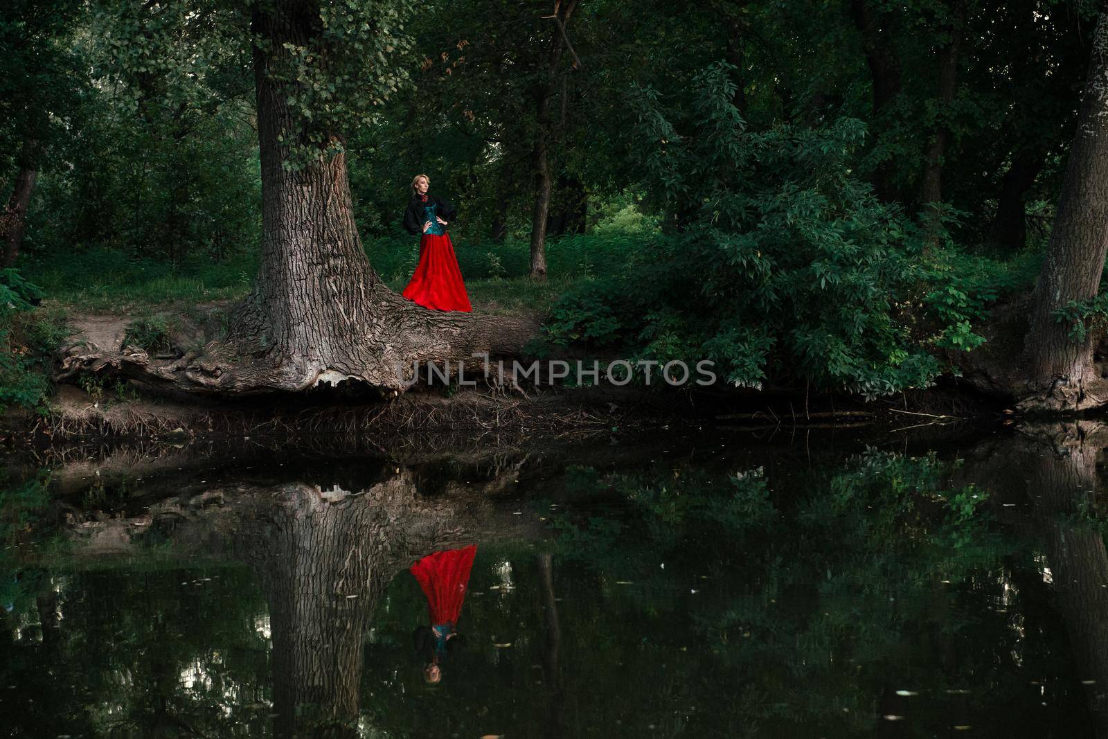 Girl model with white hair in a retro dress with ruffles in a green park