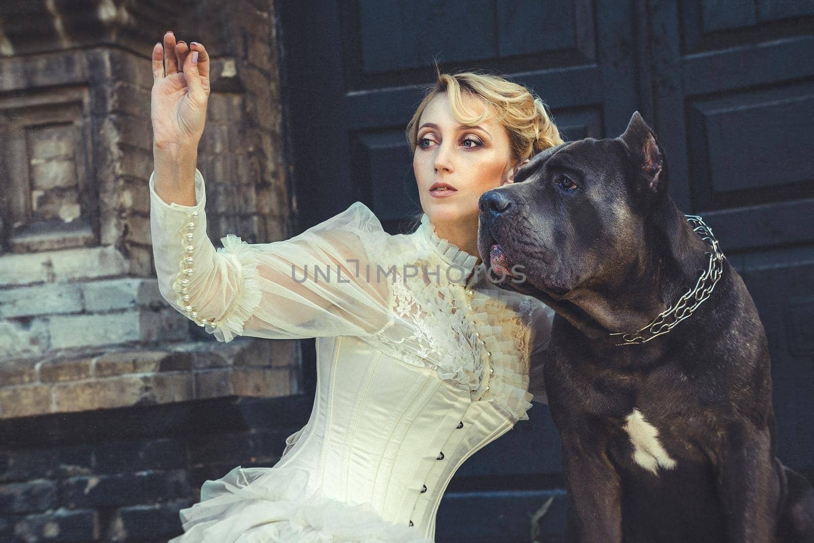 Girl in an old dress with ruffles and a big dark dog