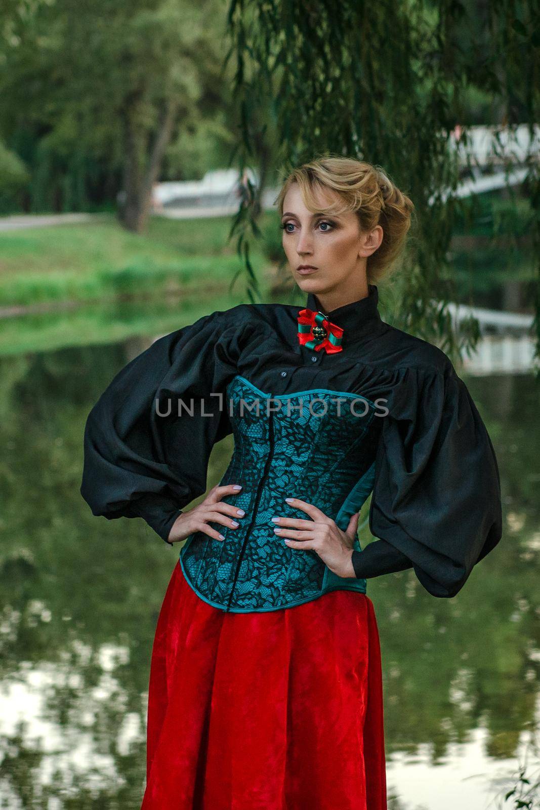 Girl model with white hair in a retro dress with ruffles in a green park