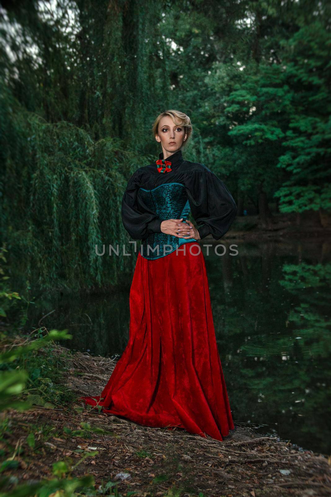 Girl model with white hair in a retro dress with ruffles in a green park