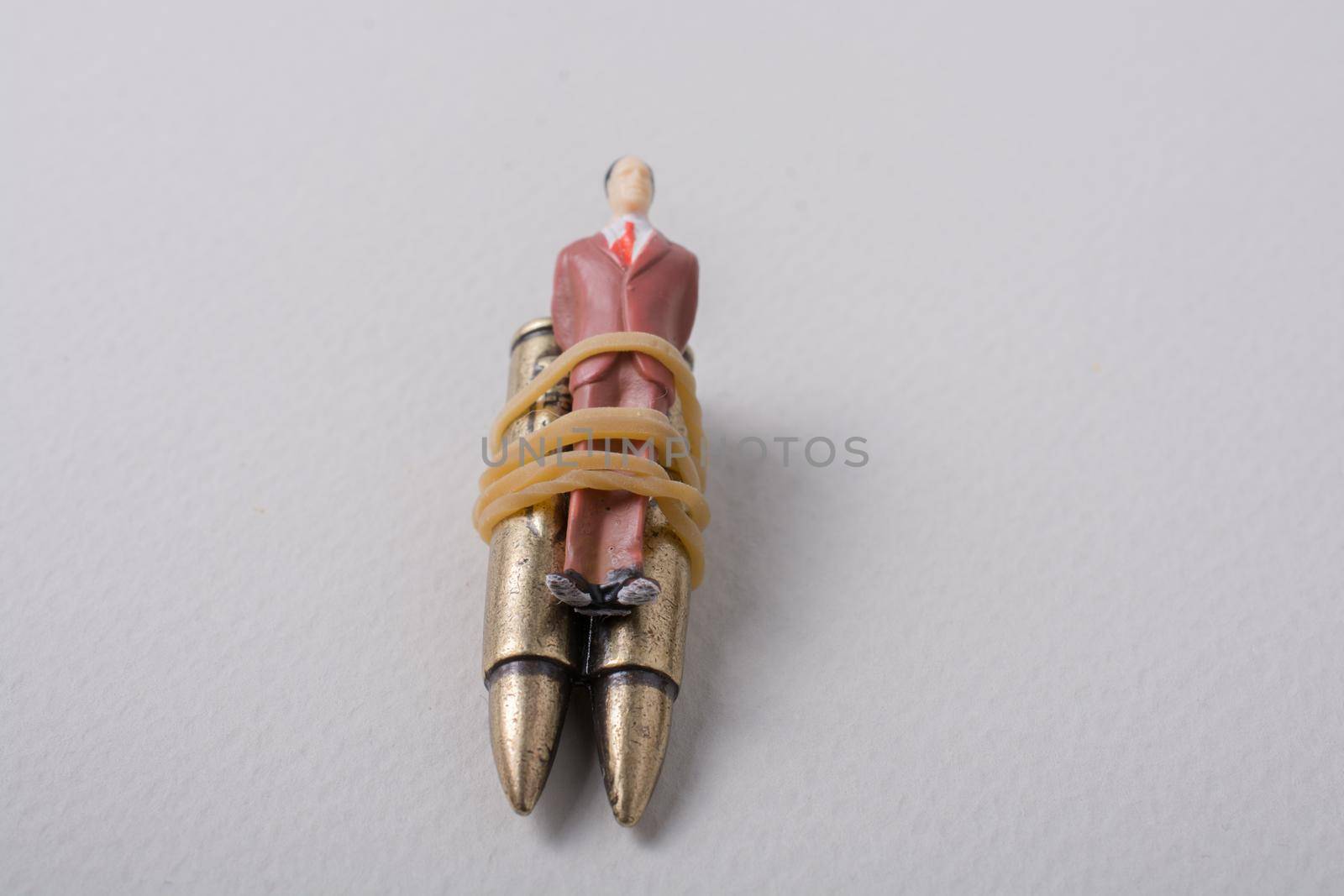 Man figurine tied to a  Bullet as anti-war photography