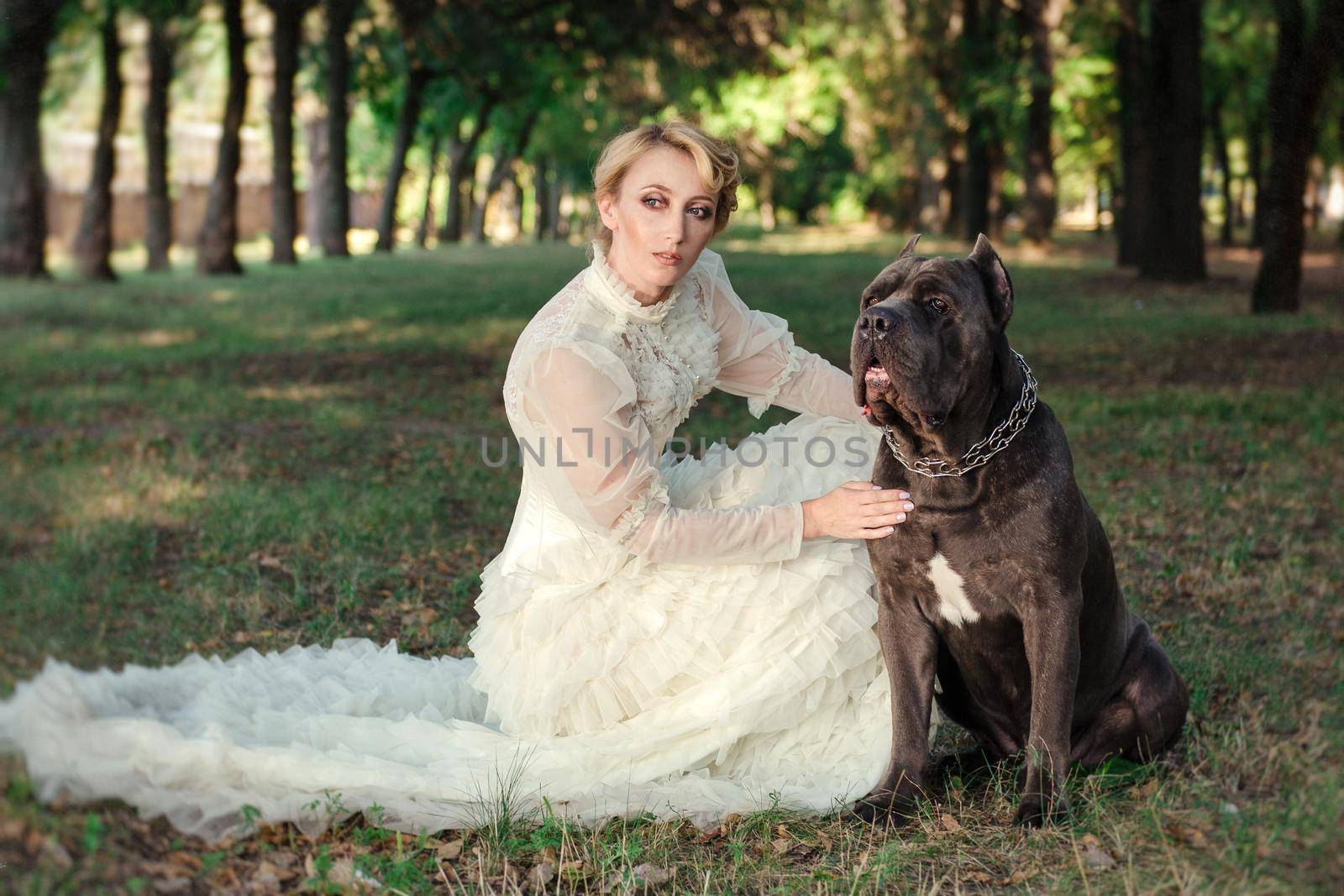 Girl in an old dress with ruffles and a big dark dog