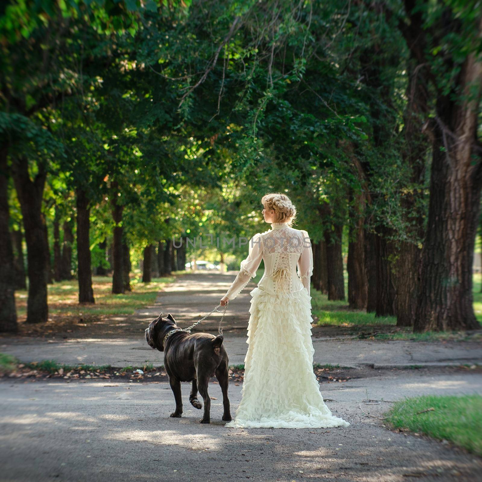 Girl in an old dress with ruffles and a big dark dog