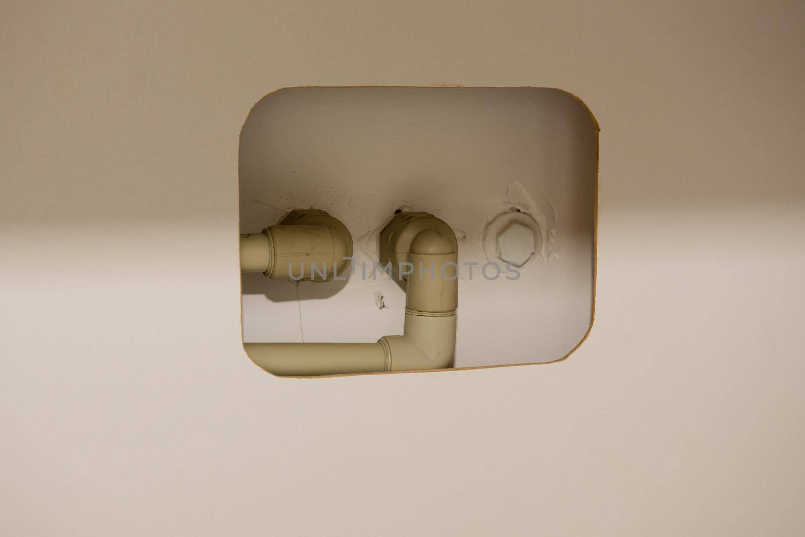 Hole in furniture for plastic water pipes in an apartment. Close-up. by leonik