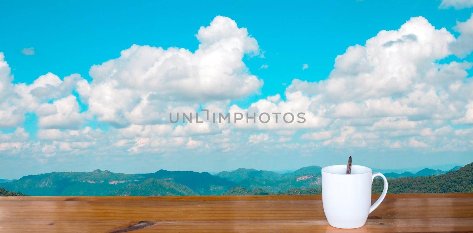 coffee cup on wooden table There is a sky background.