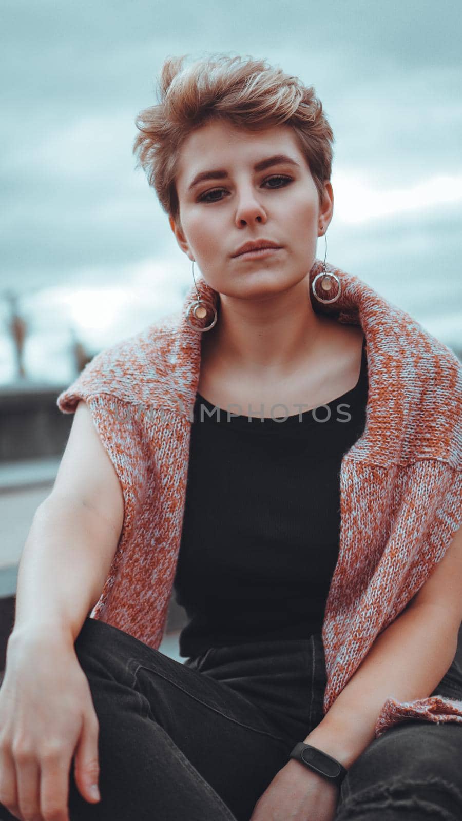 Young woman with trendy short blonde hair outdoor portrait at city