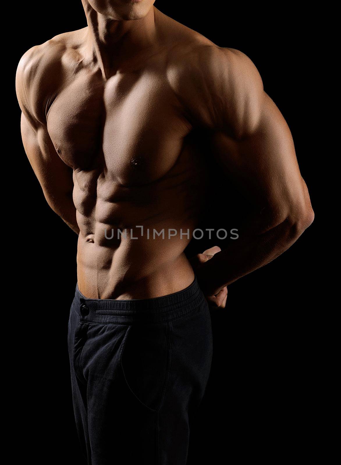 Epic bodywork. Cropped shot of a ripped man body on black background