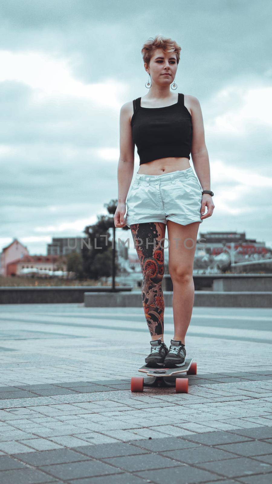 Beautiful young girl with tattoos with longboard by natali_brill