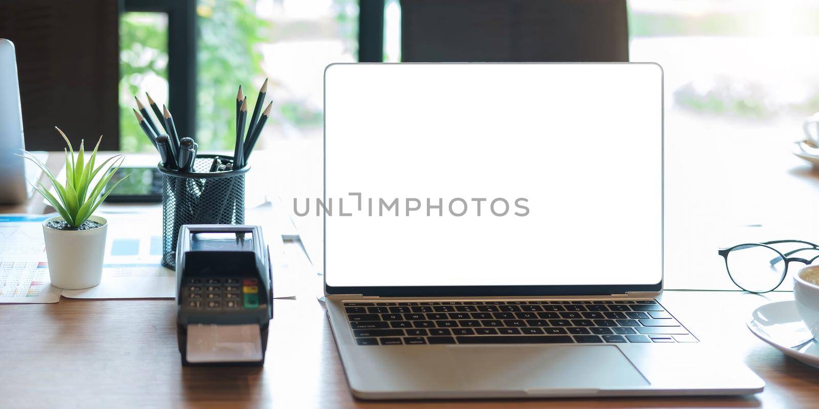 laptop blank screen with EDC machine on a table in a coffee shop by wichayada