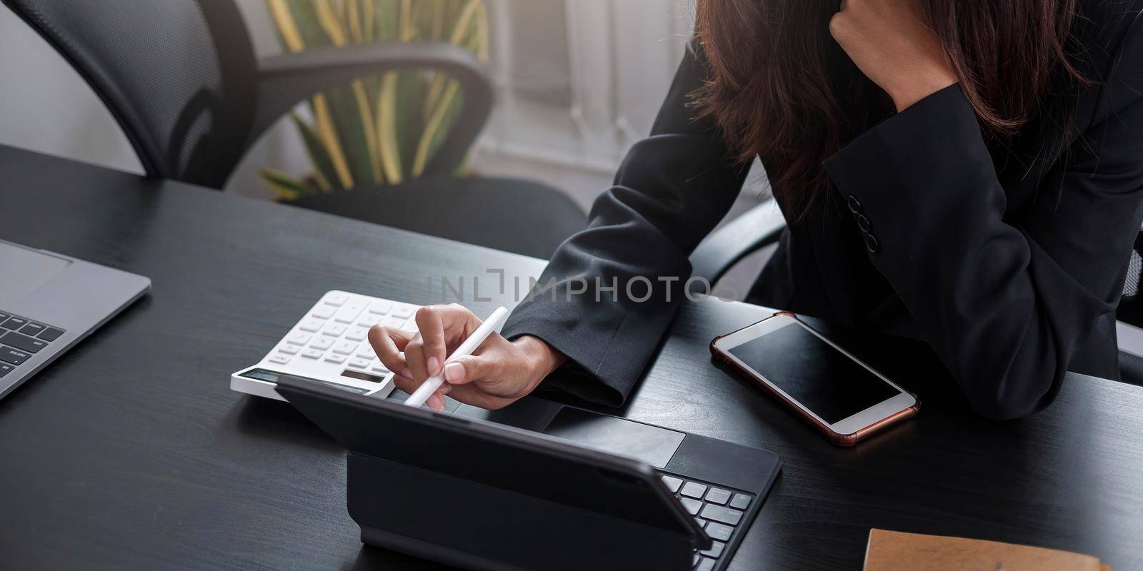 Business woman using calculator for do math finance on wooden desk in office and business working background, tax, accounting, statistics and analytic research concept by wichayada