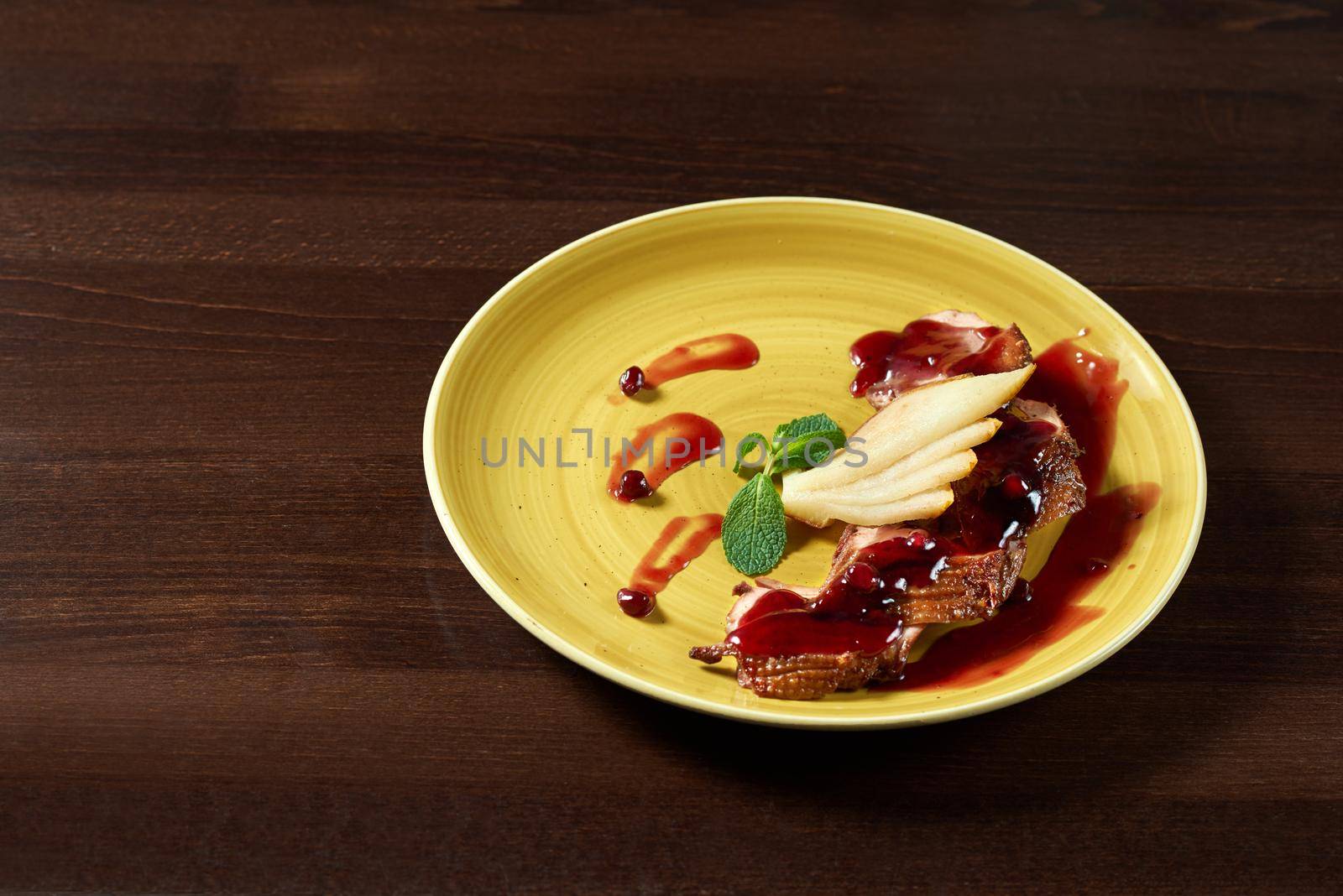 Cranberries sauce with sliced duck meat. Shot of a sliced duck meat served with pears under cranberries sauce