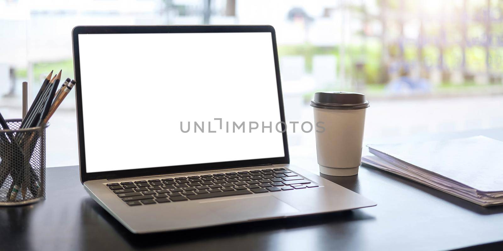 Blank screen Laptop computer and poster workspace background in modern office by wichayada