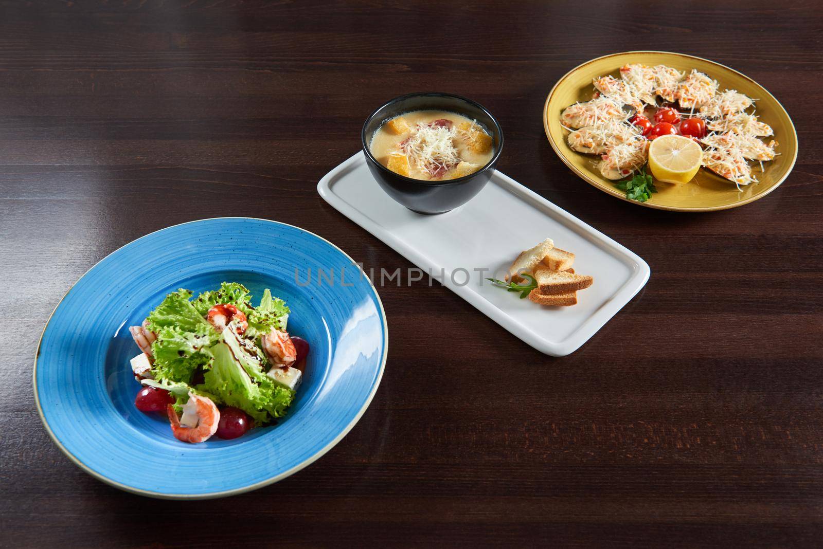 Enjoy your meal. Set of three delicious dishes served on a restaurant table