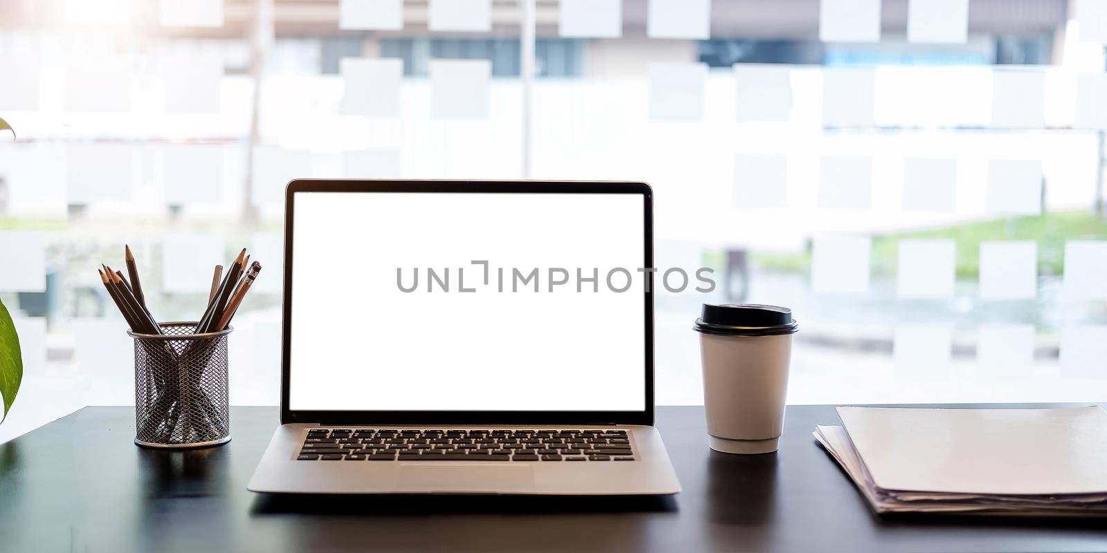 Laptop with blank screen on black table with cup and peper. by wichayada