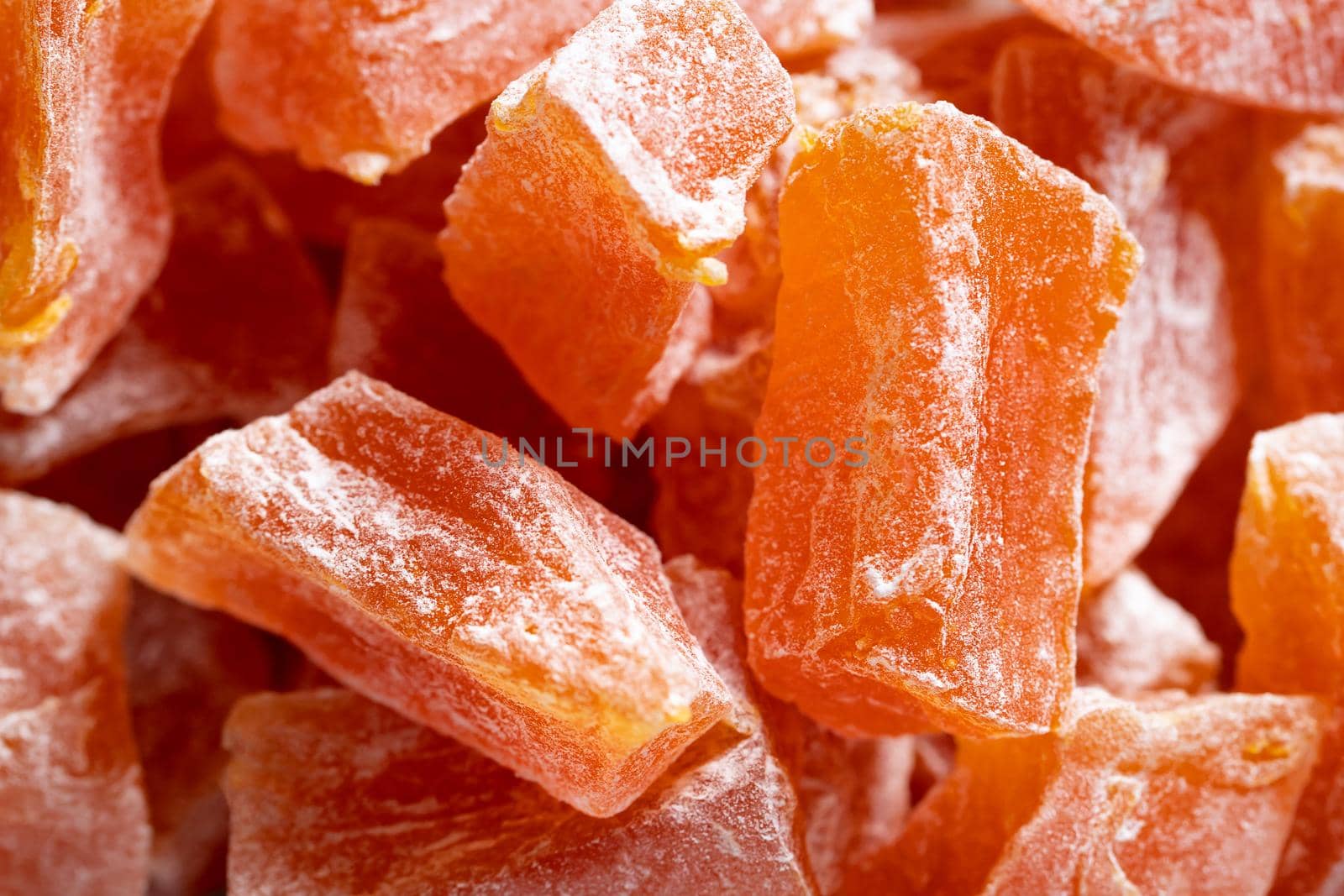 Close-up of Natural farm homemade candied pumpkin fruits sprinkled with powdered sugar, food background, texture by galsand