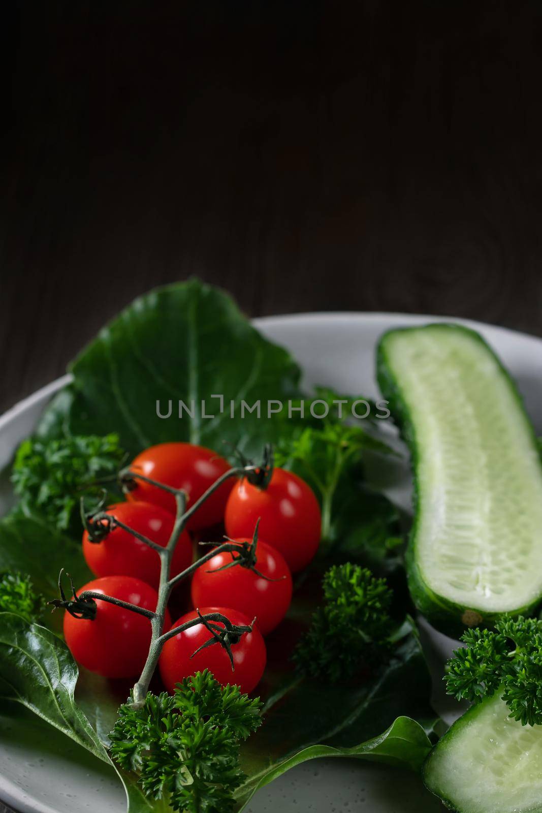 Fresh vegetables and herbs in a plate on a wooden table. Concept of vegetarianism and healthy eating. Copyspace