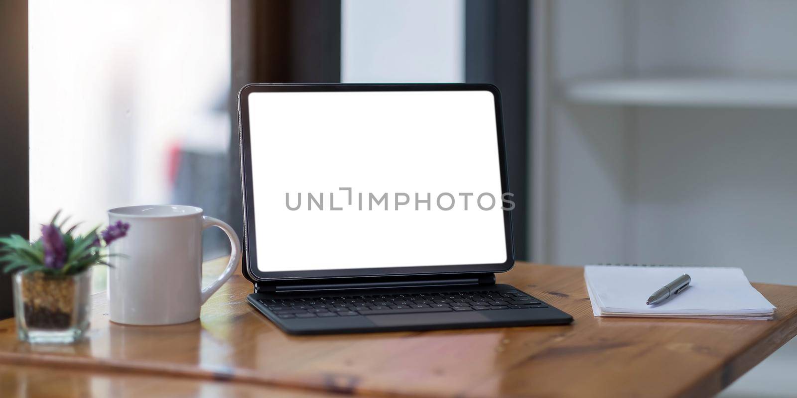 Blank screen Laptop computer and poster workspace background in modern office.