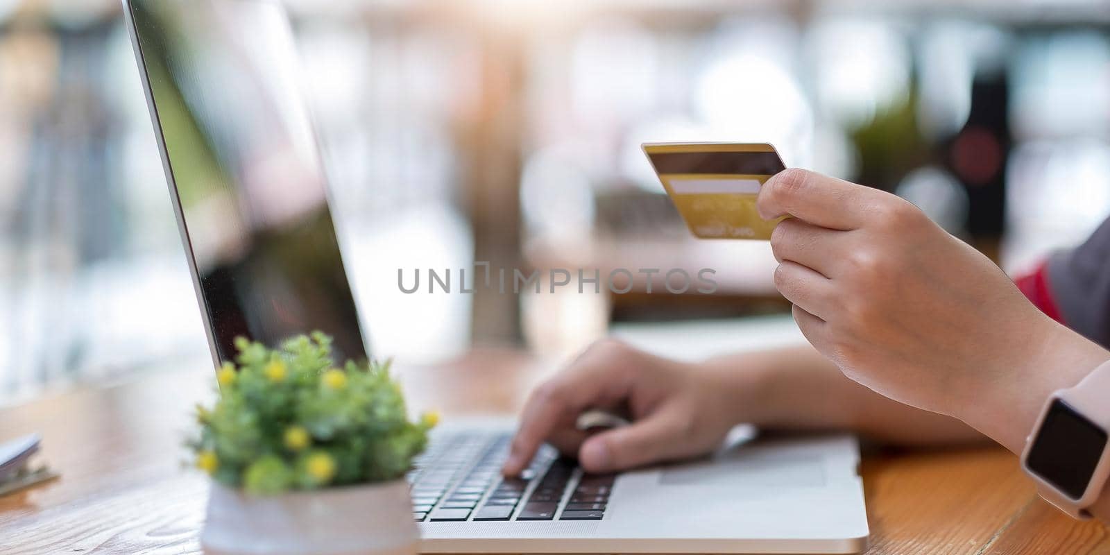 Online payment,Young woman's hands using computer and hand holding credit card for online shopping.