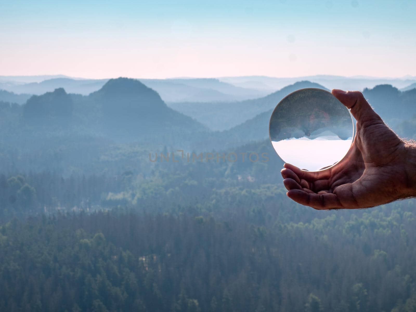 Look to the Grosser Zschand valley through the crystal ball in hand. Popular glass lens effect, abstract view
