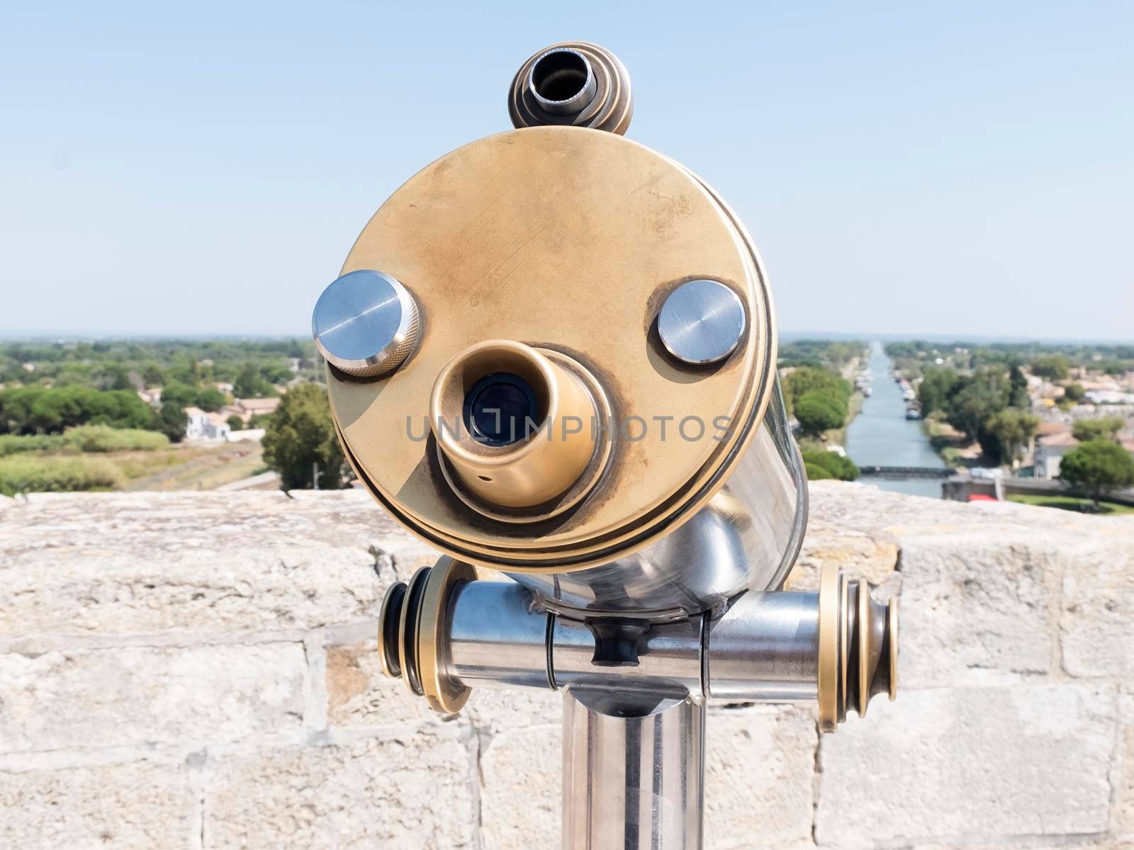 Coin-operated binoculars looking out over a river landscape